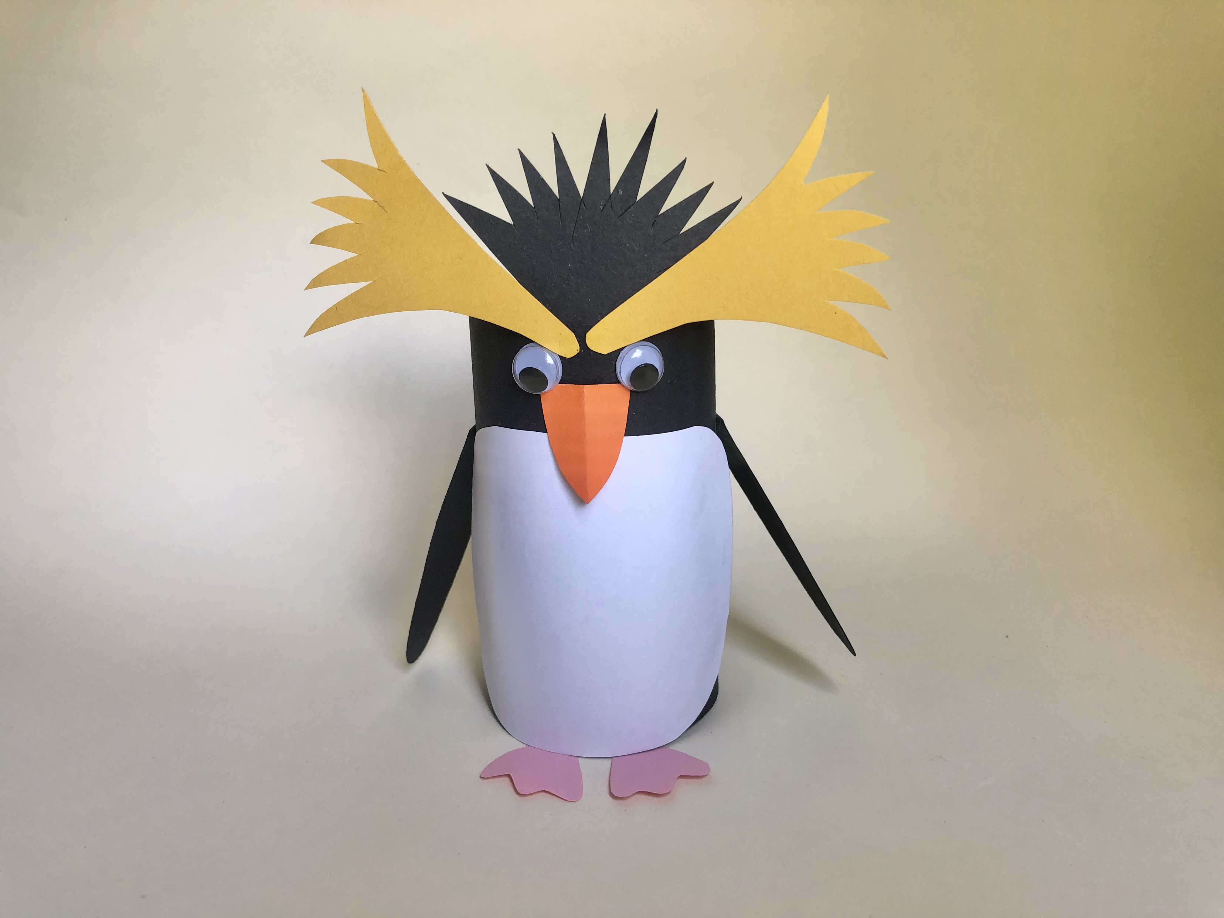 How to Create a Penguin Step 6: Finally, glue the yellow top feather shapes and black feather shape to the penguin.