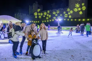 Family Skating on Ice Rink at Christmas at the Castle at Warwick Castle