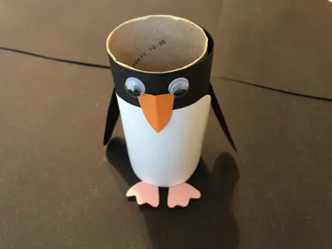 How to Create a Penguin Step 5: Glue and attach the penguin's arms, feet and beak. Then stick the eyes on so they are just over lapping the beak.